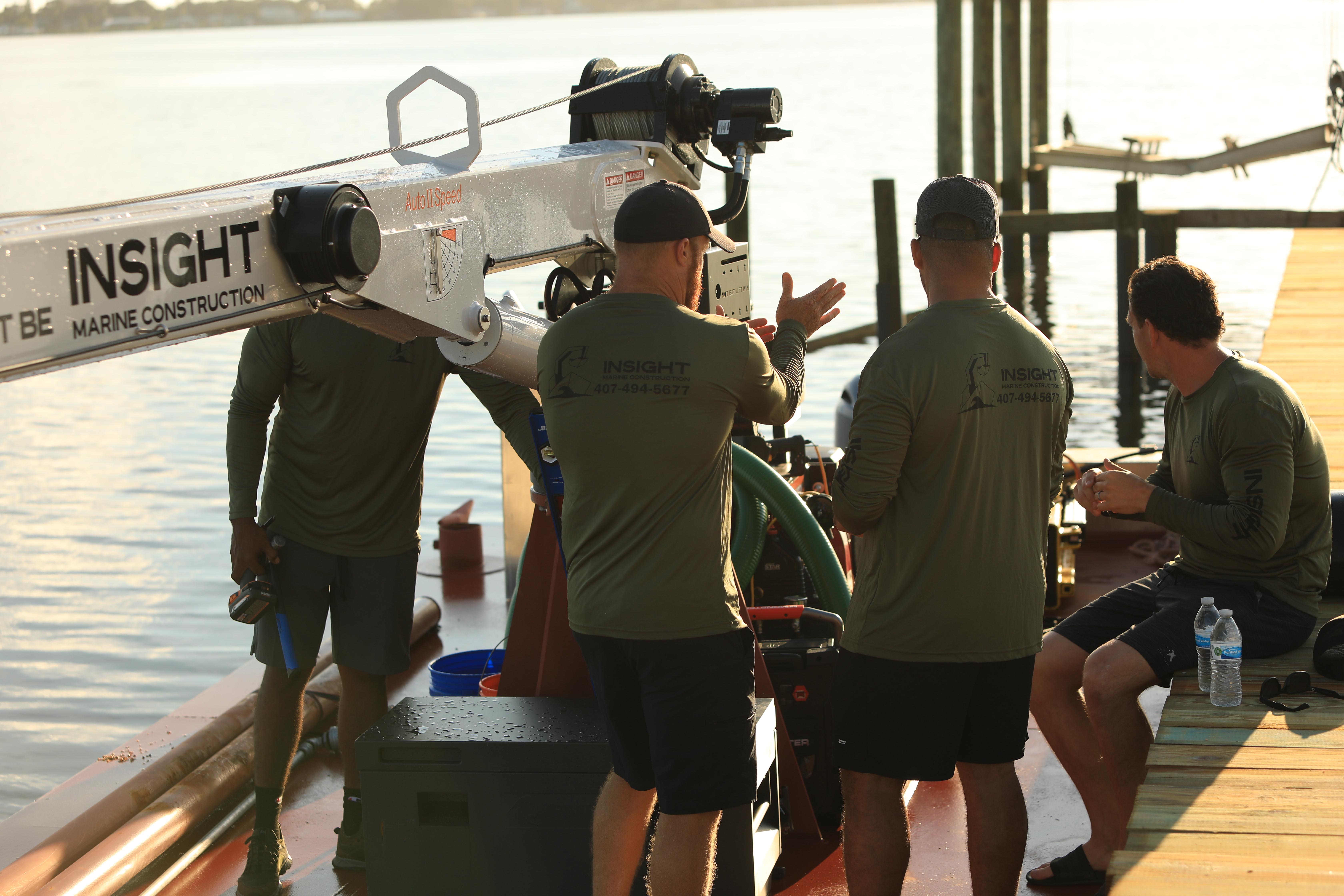 Crew assembling a boat lift beam on the barge