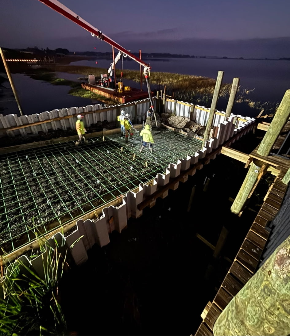Night concrete pour on a community boat ramp with a pump truck and light towers