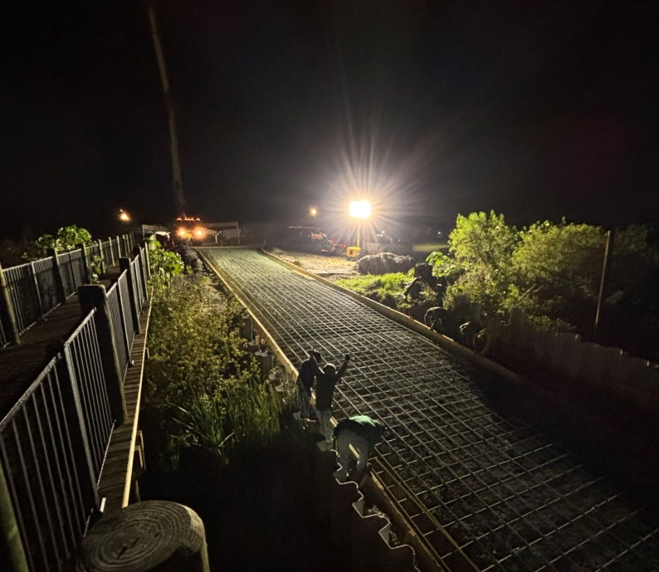 Rebar mat on a community boat ramp lit by light towers at night